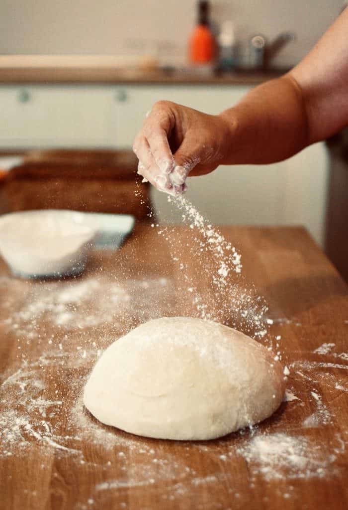 Sprinkling flour on dough. Stranger danger can be anyone you don't know cooking your food. 