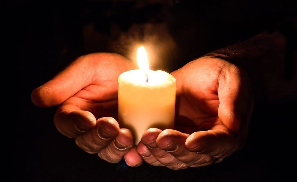 Candle on someone's palms. This symbolises hope for a better birthday and life. 