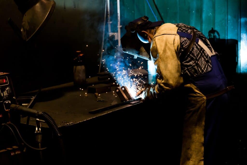 Welder working in a factory. Having no friends makes you more productive. 