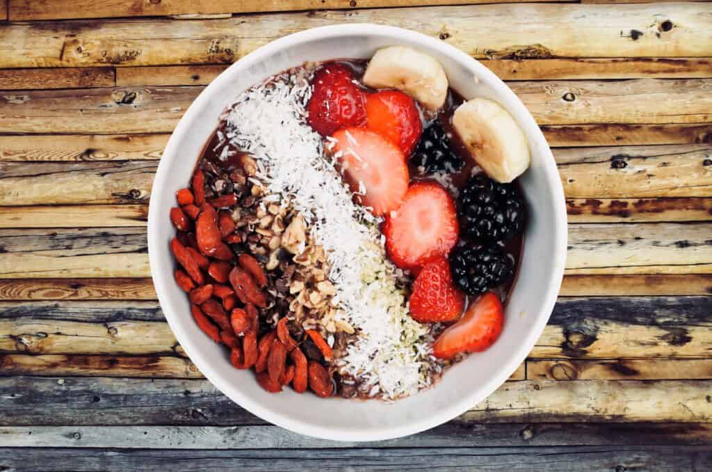 Fruit bowl. On one side there is fruit, on the other there is nuts 